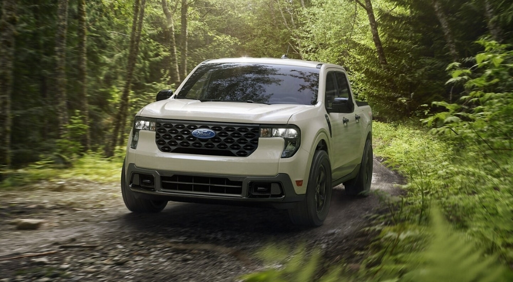 A white 2025 Ford Maverick FX4 is shown off-road on a trail.