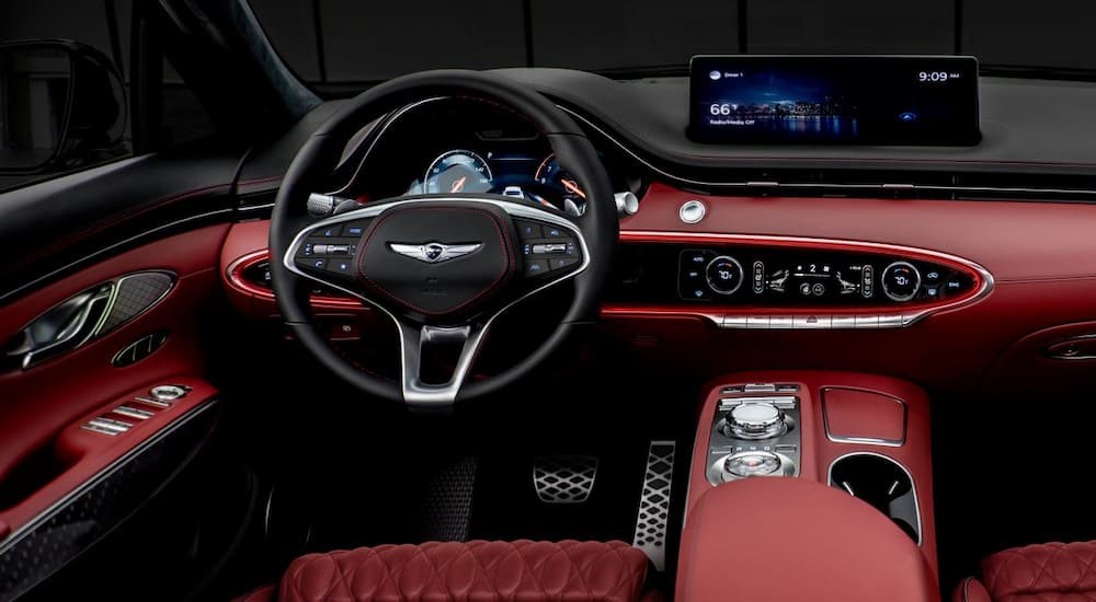 The black and red interior and dash in a 2025 Genesis GV70 is shown.