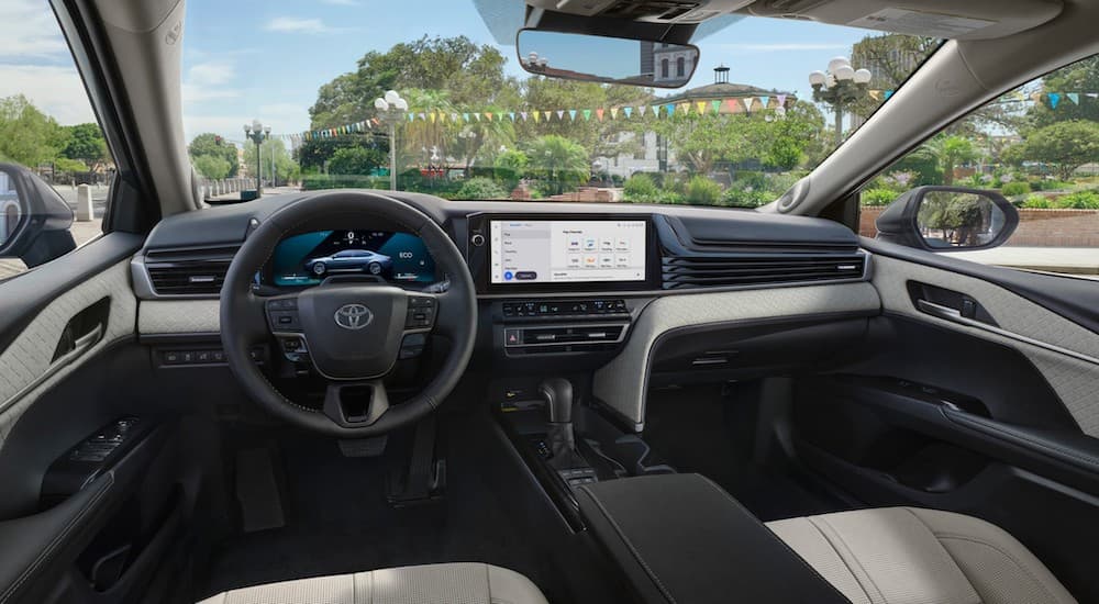 the black and white interior of a 2025 Toyota Camry is shown from the drivers seat.