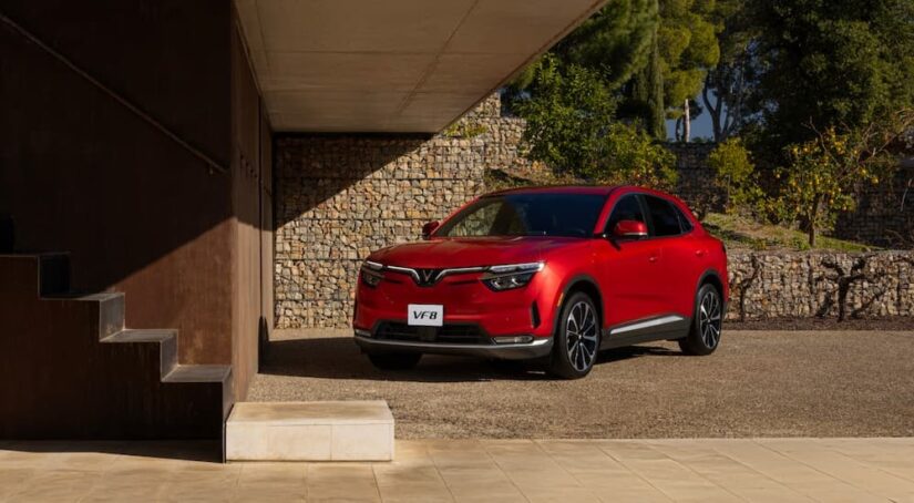 A red 2024 VinFast VF8 is shown parked on a driveway.