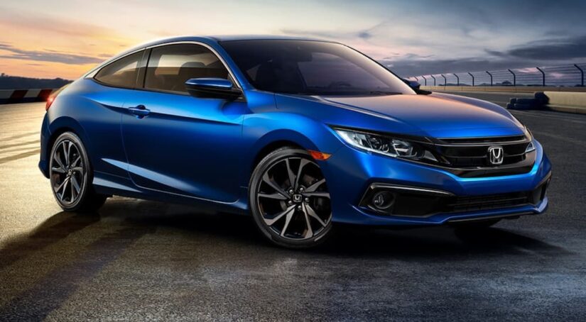 A blue 2020 Honda Civic Sport Coupe is shown from the front at an angle after leaving a dealer that has a used Honda Civic for sale.