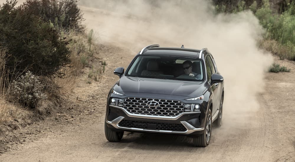 A black 2022 Hyundai Santa Fe off-roading after visiting a Hyundai dealer.