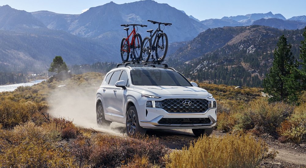 A white 2022 Hyundai Santa Fe driving off-road.