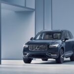 A blue 2024 Volvo XC90 parked in a modern gallery.