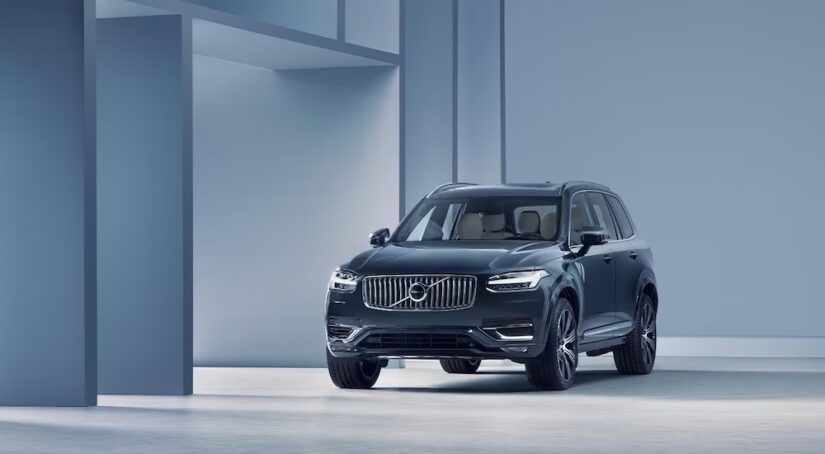 A blue 2024 Volvo XC90 parked in a modern gallery.