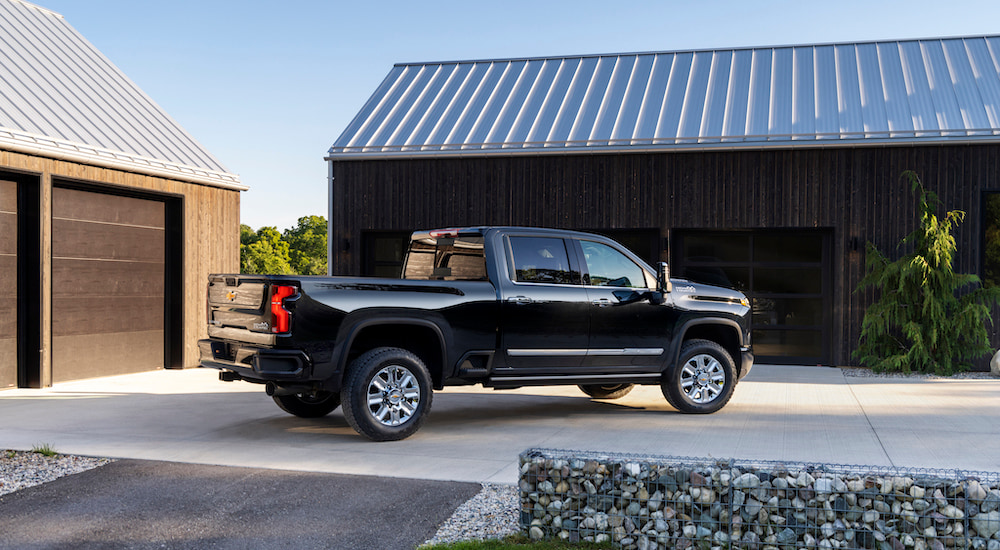 A black 2024 Chevy Silverado 2500 HD High Country is shown from the side while parked.