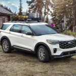A white 2025 Ford Explorer parked outside a building.