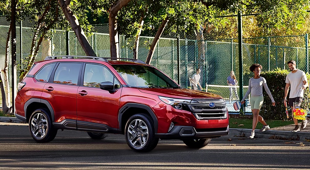 A red 2025 Subaru Forester parked next to an outdoor basketball court.