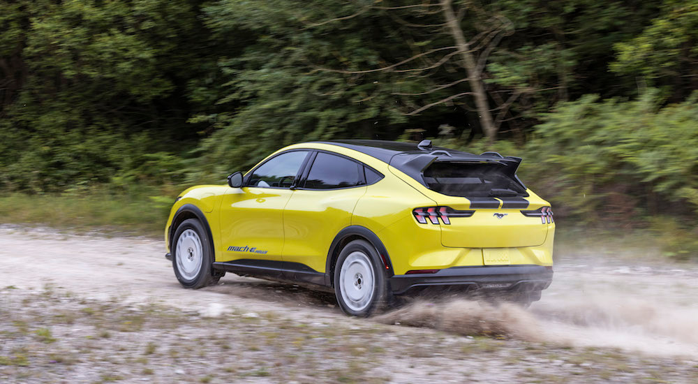 A yellow 2024 Ford Mustang Mach-E Rally is shown from the rear at an angle after leaving a Ford dealer.