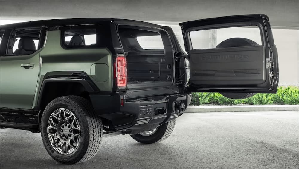 The rear end of a green 2024 GMC Hummer EV SUV is shown.