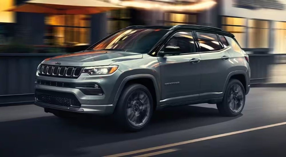 A grey 2024 Jeep Compass driving in a city.