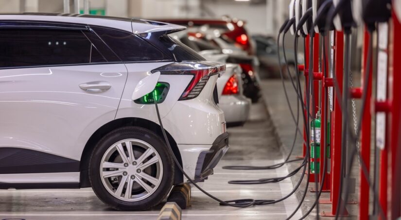 A white SUV parked and charging at a public charging station.