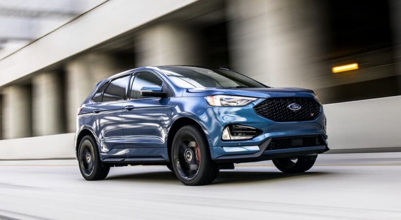 A blue 2020 Ford Edge ST is shown driving to visit used car dealers.