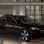 A black 2024 Mercedes-Benz C 300 4Matic sedan is shown parked at a Mercedes-Benz dealer.