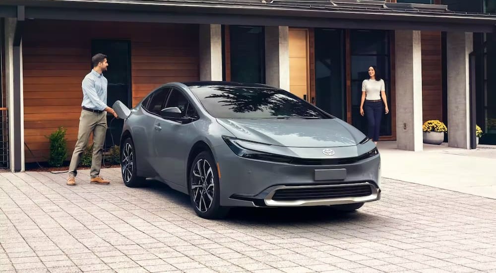 A gray 2024 Toyota Prius Prime is shown parked and charging.