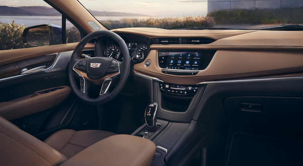 The brown interior of a 2024 Cadillac XT5 is shown from the passenger seat.