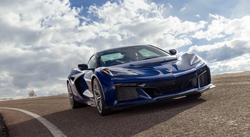 A blue 2025 Chevy Corvette ZR1 is shown on a cloudy day.