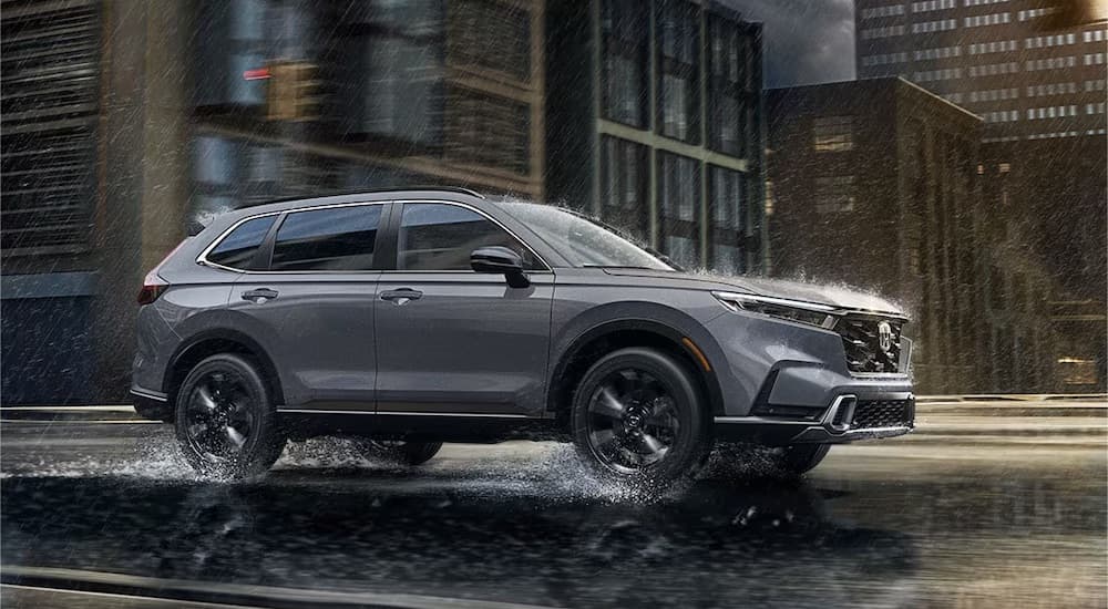 A grey 2023 Honda CR-V is shown from the side in the rain.