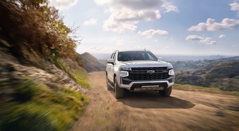 A white 2021 Chevy Tahoe Z71 is shown rounding a corner to look at used cars for sale.