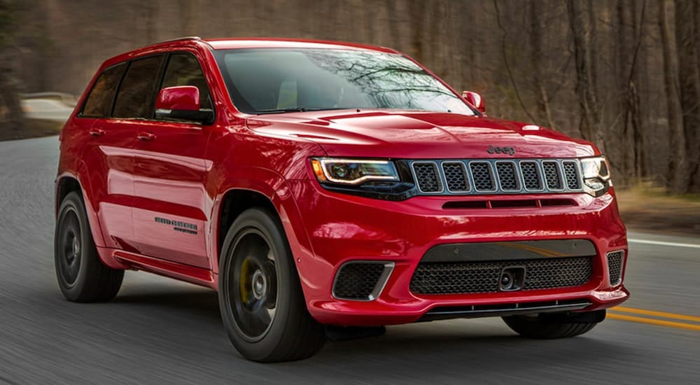 A red 2020 Jeep Grand Cherokee Trackhawk driving and angled right.