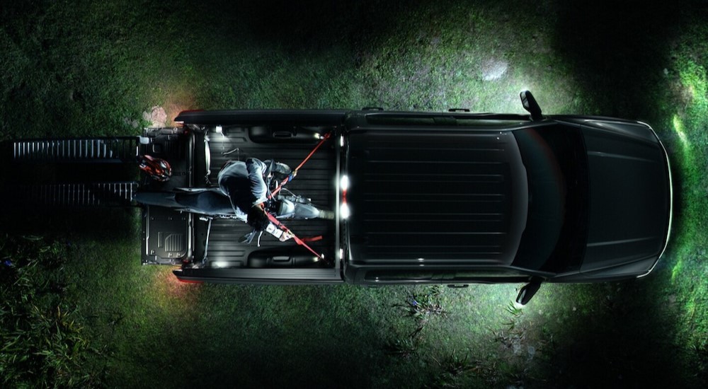 An aerial view of a parked black 2024 Ford F-150 Lightning Lariat is shown at night.