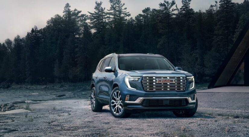 A blue 2025 GMC Acadia Denali is shown from the front at an angle.