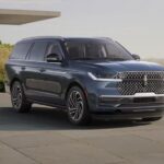 A blue 2025 Lincoln Navigator is shown parked on a driveway.