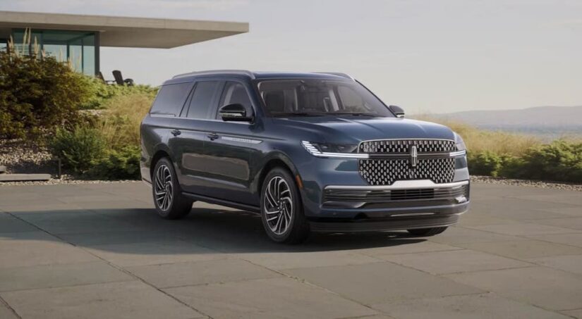 A blue 2025 Lincoln Navigator is shown parked on a driveway.