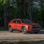An orange 2024 Chevy Trax is shown from the front at an angle after leaving a Chevy dealer.