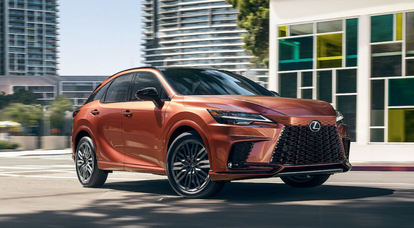 A copper 2024 Lexus RX F SPORT driving on a city street.