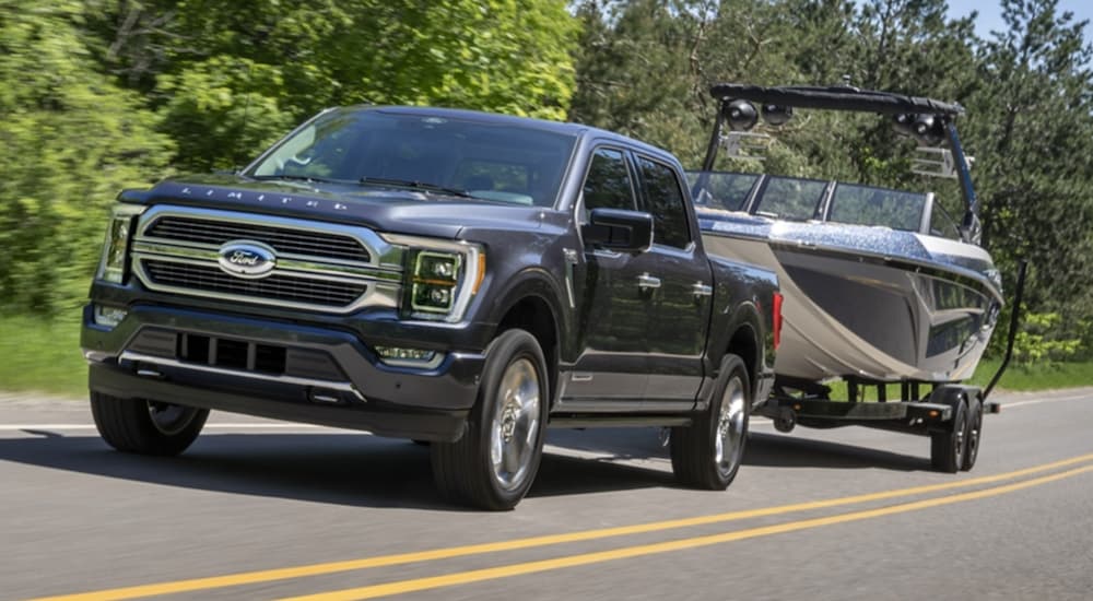 A gray 2021 Ford F-150 Limited is shown towing a boat.