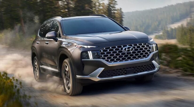 A gray 2021 Hyundai Santa Fe is shown driving off-road.