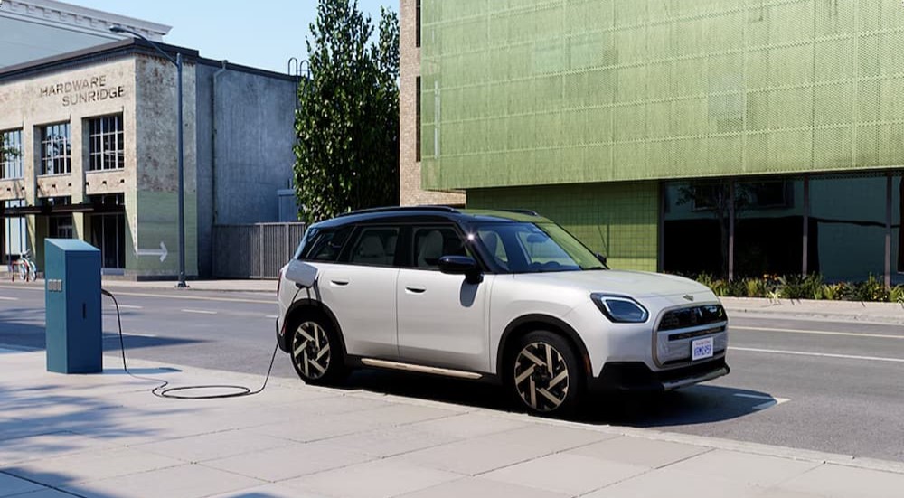 A white 2024 MINI Cooper Countryman SE ALL4 is shown parked and charging.