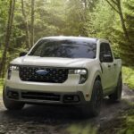 A white 2025 Ford Maverick XLT is shown driving on a dirt path.