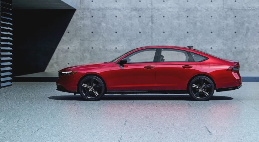 A red 2025 Honda Accord Hybrid is shown parked on a driveway.