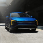 A blue 2025 Kia K4 is shown from the front after leaving a Kia dealer.