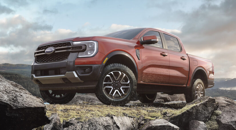 A red 2024 Ford Ranger LARIAT parked off-road on a rocky outcropping.