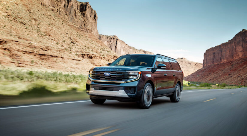 A black 2025 Ford Expedition Platinum Ultimate driving on the highway.