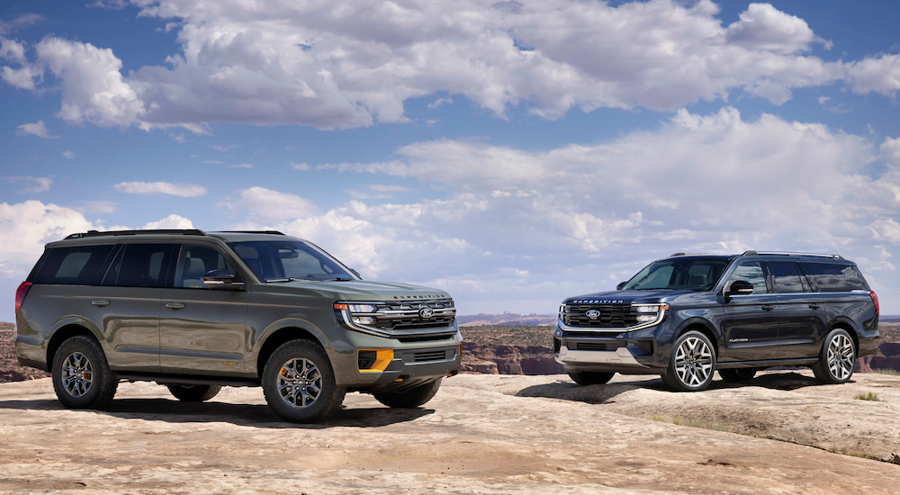 A grey 2025 Ford Expedition Tremor and a black 2025 Ford Expedition Platinum parked on a boulder.