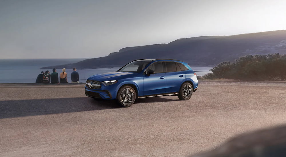 A blue 2025 Mercedes-Benz GLC parked by a lake and angled left after visiting a Mercedes-Benz dealer.