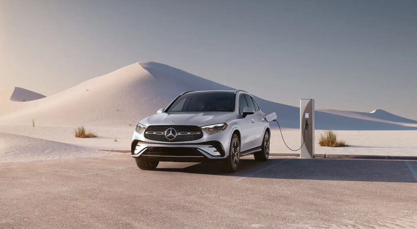 A white 2025 Mercedes-Benz GLC parked in a desert while charging.