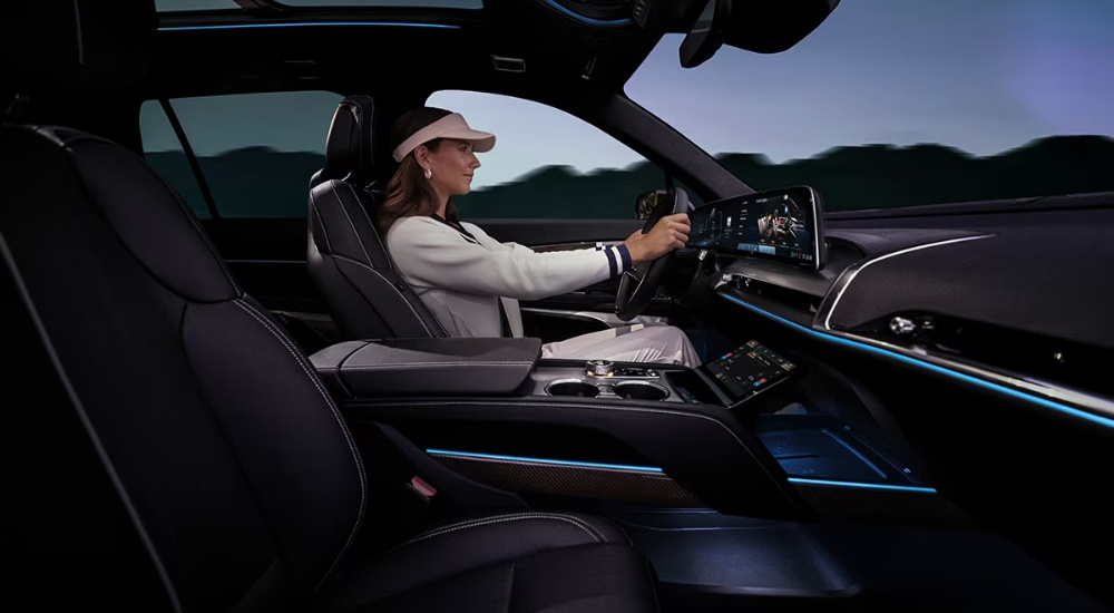 A person wearing a visor is shown driving a 2026 Cadillac VISTIQ.