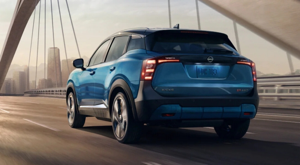 A blue 2025 Nissan Kicks SR is shown driving over a bridge.