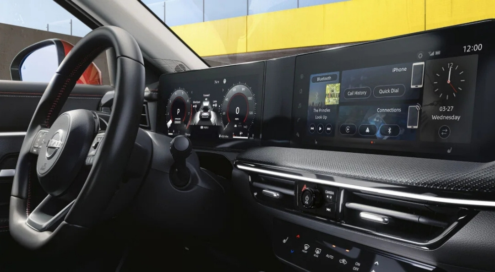 A close up shows the infotainment screen and black interior in a 2025 Nissan Kicks SR.