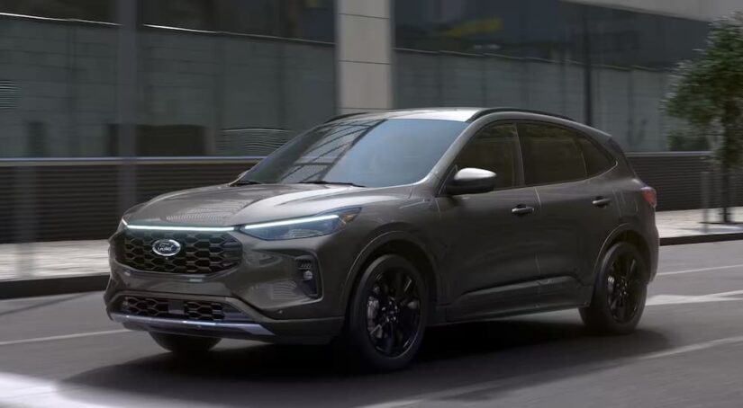 A grey 2024 Ford Escape driving on a city street.