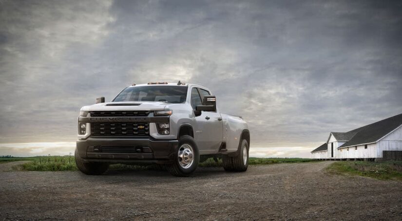 A white 2020 Chevy Silverado 3500 HD is shown from the front at an angle after leaving a dealer that has used cars for sale.