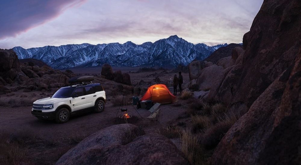 A white 2023 used Ford Bronco Sport for sale parked in the mountains at a campsite.