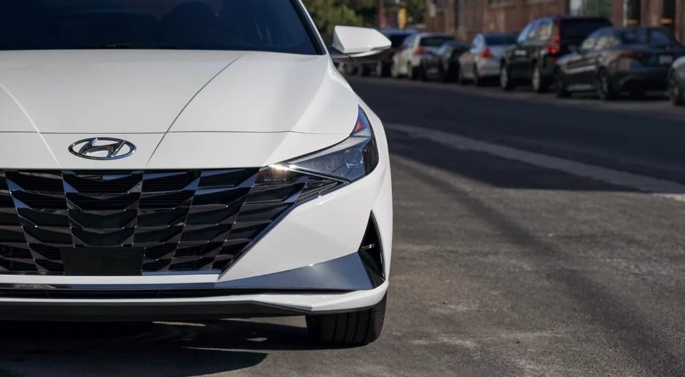 A close-up of the front end of a white 2022 Hyundai Elantra is shown.