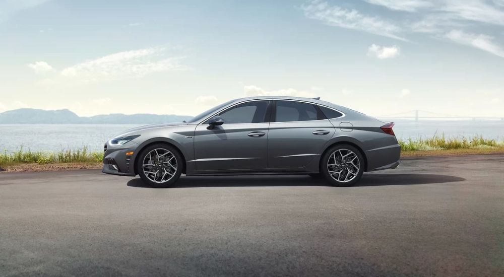 A silver 2022 Hyundai Sonata N-Line is shown parked near a lake.