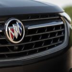 A close-up on the grille of a black 2024 Buick Envision GT is shown.
